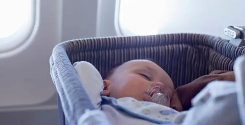 Travelling can be an adventure, especially when you have a baby in tow. From packing their essentials to making sure you've got everything under control, travelling with a little one requires a little extra thought and preparation. One of the many decisions that parents face when flying with their baby is choosing the perfect airplane seat. The eternal debate between window or aisle seat with baby comes down to personal preferences and your baby's unique needs. . In this comprehensive article, we'll examine the pros and cons of each option to help you make the best choice for your family. The Tale of Two Seats: Window vs. Aisle The Window Seat Pros The window seat is an appealing option for many reasons. For one, it provides a natural barrier between your baby and the rest of the passengers. This can be particularly helpful if your baby is easily distracted or tends to grab things. The window also acts as a built-in source of entertainment; your little one might be fascinated by the view outside, which can help keep them occupied during the flight. Another advantage of choosing the window seat with a baby is the extra privacy it provides, especially during feeding times. If you need to breastfeed, the window seat can give you a bit more seclusion than the aisle seat. Cons Despite the perks, the window seat also has its disadvantages. For instance, it can be more challenging to get in and out of the seat with a baby, especially if the passengers in the middle and aisle seats are asleep or watching movies. This could make diaper changes and restroom trips a bit more cumbersome. The Aisle Seat Pros The aisle seat is a popular choice for parents because of the easy access it provides. It makes getting up for diaper changes, restroom visits, and walking with a fussy baby much more convenient. Aisle seats also allow for quicker and smoother boarding and deplaning, which can be a blessing when you have a tired or restless baby. Another advantage of the aisle seat is the extra legroom it provides. While this may not be a significant factor for your baby, it can make a big difference to your comfort level during the flight. Cons The downside of the aisle seat is the lack of privacy and the increased likelihood of disturbances. With people walking by and the flight attendants serving food and drinks, it can be challenging to maintain a calm and quiet environment for your baby. Additionally, there's the risk of your baby's hands or legs being bumped by passengers or service carts. Additional Tips for Flying with a Baby Regardless of whether you choose a window or aisle seat, there are some additional tips to help ensure a smoother and more enjoyable flight with your baby: Timing is Everything Try to book your flight during your baby's usual nap or sleep time. This can increase the chances that your baby will sleep during the flight, making the journey more comfortable for everyone. Dress for Comfort Dress your baby in layers to accommodate varying temperatures on the plane. Opt for comfortable, soft clothes that allow for easy diaper changes and ensure your baby is warm and cozy throughout the flight. Bring a Baby Carrier A baby carrier can be a lifesaver when navigating airports and boarding the plane. It allows you to have your hands free while keeping your baby close and secure. Pack Entertainment and Comfort Items Bring a few familiar toys and comfort items, such as a favorite blanket or stuffed animal, to help your baby feel more at ease during the flight. Additionally, pack age-appropriate activities or toys to keep your baby entertained and engaged. Prepare for Ear Pressure Changes in cabin pressure can cause discomfort for babies, especially during takeoff and landing. To help alleviate this, offer your baby a pacifier, bottle, or breastfeed during these times to encourage swallowing, which can help equalize the pressure in their ears. Seek Assistance from Flight Attendants Don't hesitate to ask for help from flight attendants if you need assistance with your baby or have any questions. They are usually more than willing to help make your flight more comfortable and can provide useful tips and resources. Practice Patience and Flexibility Flying with a baby can be unpredictable, and even the best-laid plans can go awry. Be prepared to adapt to your baby's needs and remain patient and understanding. Remember that other passengers were once babies too, and most people will empathize with your situation. In the end, the choice between a window or aisle seat with a baby will depend on your individual needs and preferences. Consider the pros and cons of each option and make a decision that best suits your family's requirements. By following these additional tips and maintaining a positive attitude, you'll be well on your way to a successful and enjoyable flight experience with your little one. Extra Measures for a Stress-Free Flight While the choice between a window or aisle seat with a baby is crucial, there are additional measures you can take to ensure a stress-free and pleasant flight experience for you and your baby. Familiarize Yourself with Airline Policies Each airline has different policies regarding travelling with infants, such as fees, age restrictions, and baggage allowances. Familiarize yourself with these policies and make any necessary arrangements in advance to avoid surprises on the day of travel. Reserve Seats in Advance Whenever possible, reserve your seats in advance to ensure you get your desired seating arrangement, whether it's a window or aisle seat. This can also help you avoid the stress of not being seated together as a family on the plane. Pack Extra Supplies It's always better to be over-prepared when flying with a baby. Bring extra diapers, wipes, clothes, and snacks in case of delays or unexpected incidents. This will give you peace of mind and allow you to focus on enjoying the journey. Bring Documentation If your baby is travelling internationally or qualifies for a lap infant ticket, make sure you have all necessary documentation, such as passports, birth certificates, and vaccination records. Having these documents readily available will help expedite the check-in process and ensure a smooth travel experience. Choose Direct Flights When possible, choose direct flights to minimize layovers and the hassle of navigating multiple airports with a baby. Although direct flights might be more expensive, the convenience and reduced stress can be well worth the extra cost. Arrive Early Give yourself plenty of time to navigate the airport, check in, go through security, and board the plane. Arriving early can help reduce stress and allow you to handle any unexpected situations with more ease. Stay Hydrated and Well-rested Travelling can be exhausting, especially for new parents. Ensure you are well-rested before your flight and stay hydrated throughout the journey. Taking care of yourself will make it easier to care for your baby and handle any challenges that arise. Connect with Other Parents Don't be afraid to connect with other parents on the plane. They can offer support, advice, and understanding, making the flight more enjoyable and less isolating. By considering the advantages and disadvantages of window and aisle seats, preparing thoroughly, and implementing these additional measures, you'll be well-equipped to navigate the challenges of flying with a baby. With the right mindset and a well-thought-out plan, you can make your flight experience a memorable and enjoyable part of your family's travels. Creating a Positive In-flight Environment Beyond choosing between a window or aisle seat, ensuring a positive in-flight environment for your baby is essential for a pleasant flying experience. Here are some additional tips to help you create a comfortable atmosphere for your baby during your journey. Manage Cabin Noise Airplane cabins can be noisy, which may disturb your baby or make it difficult for them to sleep. Consider bringing noise-cancelling headphones or soft earplugs specifically designed for babies to help reduce the impact of the cabin noise. Use Comforting Routines Incorporate familiar routines from home to help your baby feel secure during the flight. For example, if you usually read them a bedtime story or sing a lullaby before sleep, continue to do so on the plane. This can help signal to your baby that it's time to rest and provide a sense of familiarity and comfort. Encourage Movement and Play When it's safe and allowed, encourage your baby to move around, stretch, and play, particularly if it's a long-haul flight. This can help keep them entertained and alleviate restlessness. Keep Calm and Reassure Your Baby Your baby can pick up on your emotions and stress, so try to remain calm and composed throughout the flight. If your baby becomes fussy or upset, reassure them with gentle touches, soothing words, and a calm demeanor. Be Prepared for Changes in Cabin Temperature Cabin temperatures can fluctuate during a flight, so it's essential to dress your baby in layers and bring a light blanket to ensure they stay comfortable throughout the journey. Being prepared for temperature changes will help your baby stay cozy and content. Seek Out Family-friendly Airports and Airlines When planning your trip, consider choosing airlines and airports that offer family-friendly amenities and services, such as dedicated family lanes at security, complimentary strollers, or play areas for children. These services can make your travel experience more enjoyable and stress-free. Communicate with Fellow Passengers A little communication goes a long way in creating a positive in-flight environment. If you sense that your baby's fussiness is bothering nearby passengers, acknowledge the situation and apologize if necessary. Most people will appreciate your understanding and may even offer support or assistance. By implementing these tips and strategies, you can create a positive in-flight environment for your baby and ensure a more enjoyable flying experience for your entire family. Remember that flexibility, preparation, and a positive attitude are key to successfully navigating the challenges of flying with a baby, whether you choose a window or aisle seat. Frequently Asked Questions (FAQs) Where is the best place to sit on a plane with a baby? The best place to sit on a plane with a baby depends on your preferences and your baby's needs. If privacy and a natural barrier are essential to you, a window seat might be the best choice. On the other hand, if easy access and additional legroom are your priorities, the aisle seat could be a better option. Is the window seat safer than the aisle seat? There is no significant difference in safety between the window and aisle seats. The most important factor in ensuring your baby's safety on a flight is to follow the airline's guidelines and use an appropriate child restraint system when required. Should I fly with an infant on my lap or in a separate seat? The decision to fly with an infant on your lap or in a separate seat depends on your preferences, budget, and the child's age. While it is generally more affordable to fly with a baby on your lap, purchasing a separate seat and using an approved child restraint system can provide additional safety and comfort for your baby. What is the hardest age to fly with a baby? The hardest age to fly with a baby can vary depending on the child's temperament and development. However, many parents find that the toddler stage (between 1 and 3 years old) can be particularly challenging due to increased mobility, curiosity, and potential for tantrums. At this age, children may have difficulty staying seated and may not fully understand the concept of waiting or being quiet for extended periods. What is the disadvantage of an aisle seat? The main disadvantage of an aisle seat is the lack of privacy and the increased likelihood of disturbances. With passengers walking by and flight attendants serving food and drinks, it can be more difficult to maintain a calm and quiet environment for your baby. Additionally, there is the risk of your baby's hands, legs, or belongings being bumped by people passing by or service carts. What is the disadvantage of a window seat? The primary disadvantage of a window seat is the limited access to the aisle, which can make getting in and out of the seat more challenging. This can be particularly inconvenient when travelling with a baby, as it may require frequent trips to the restroom for diaper changes, soothing a fussy baby, or simply needing to stretch your legs. What is the safest seat for a baby seat? The safest seat for a baby seat depends on the specific aircraft and airline guidelines. In general, the safest place for a baby seat is in a rear-facing position and away from any potential impact zones, such as the bulkhead. It is essential to follow the airline's guidelines and use an approved child restraint system when required. Making the Decision: Window or Aisle Seat with Baby In conclusion, the choice between a window or aisle seat with a baby comes down to personal preferences and your baby's unique needs. While the window seat offers more privacy and a natural barrier, the aisle seat provides easier access and additional legroom. It's essential to weigh the pros and cons of each option and consider factors such as your baby's age, temperament, and the flight's duration when making your decision. Remember that no matter which seat you choose, the key to a successful flight with a baby lies in preparation and flexibility. Make sure to pack all necessary items, such as snacks, toys, and a change of clothes, and be prepared to adapt to your baby's needs throughout the flight. With some planning and patience, you can make flying with a baby a smooth and enjoyable experience for both you and your little one.